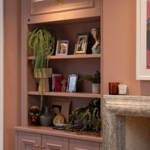 Photo of a lounge in a modern home, featuring pink painted bespoke cabinetry with decorative mouldings installed